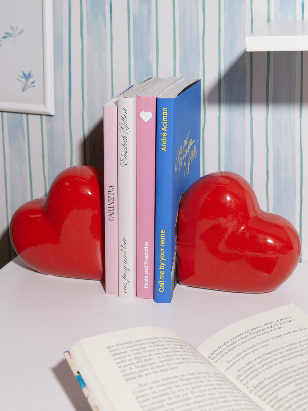 Serre-livres DOIY Love rouges disposés sur une étagère avec des livres.