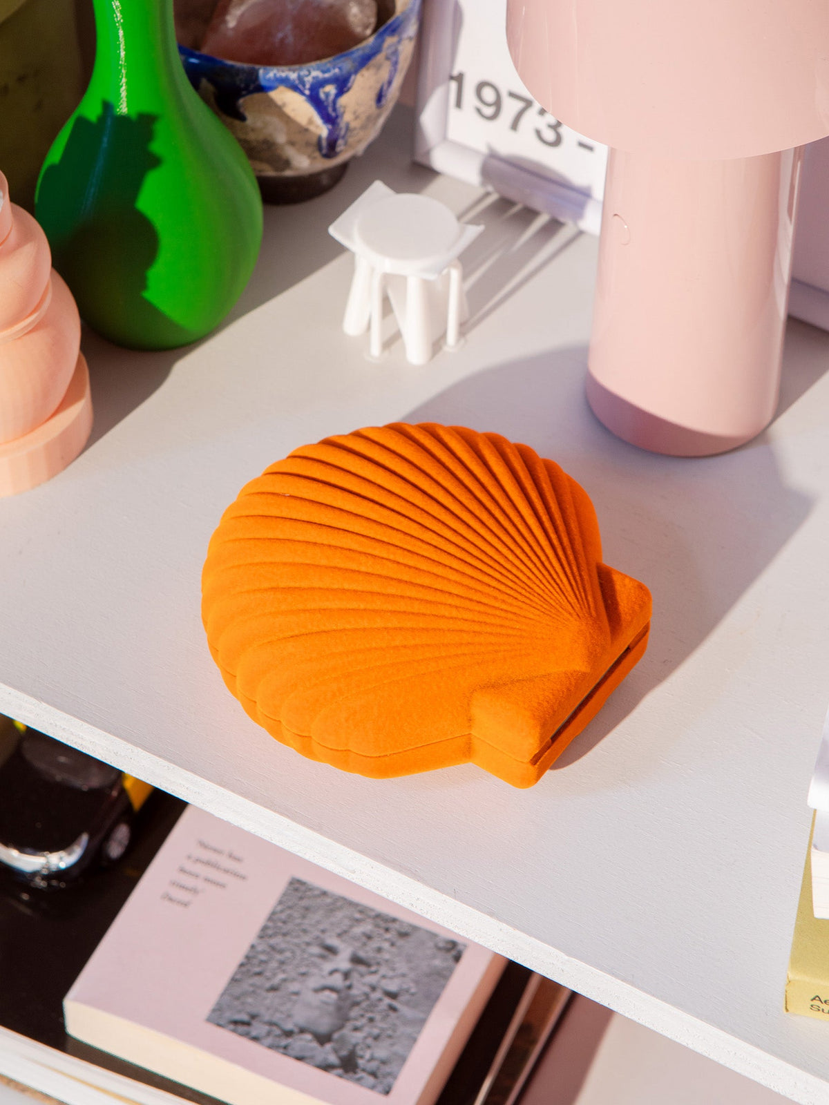 Boîte Venus orange disposée sur une console.