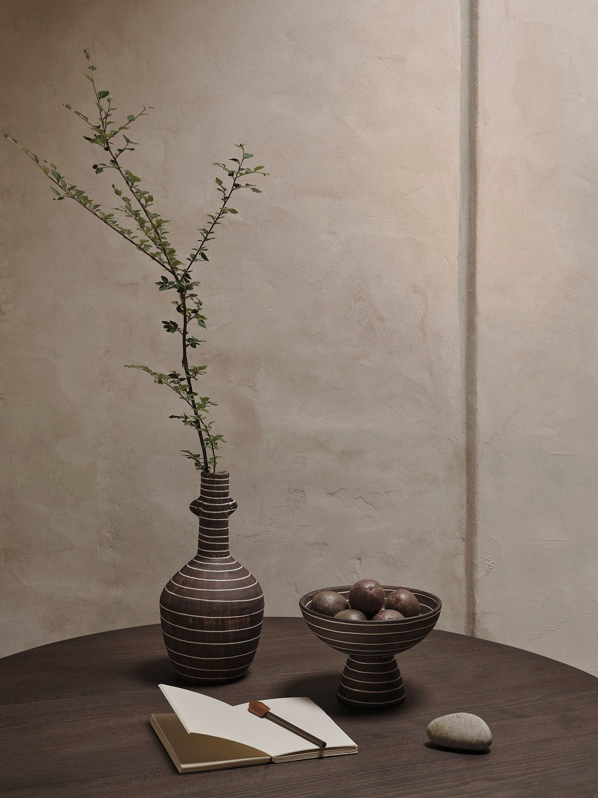 Vase Brura café et blanc avec une branche sur une table
