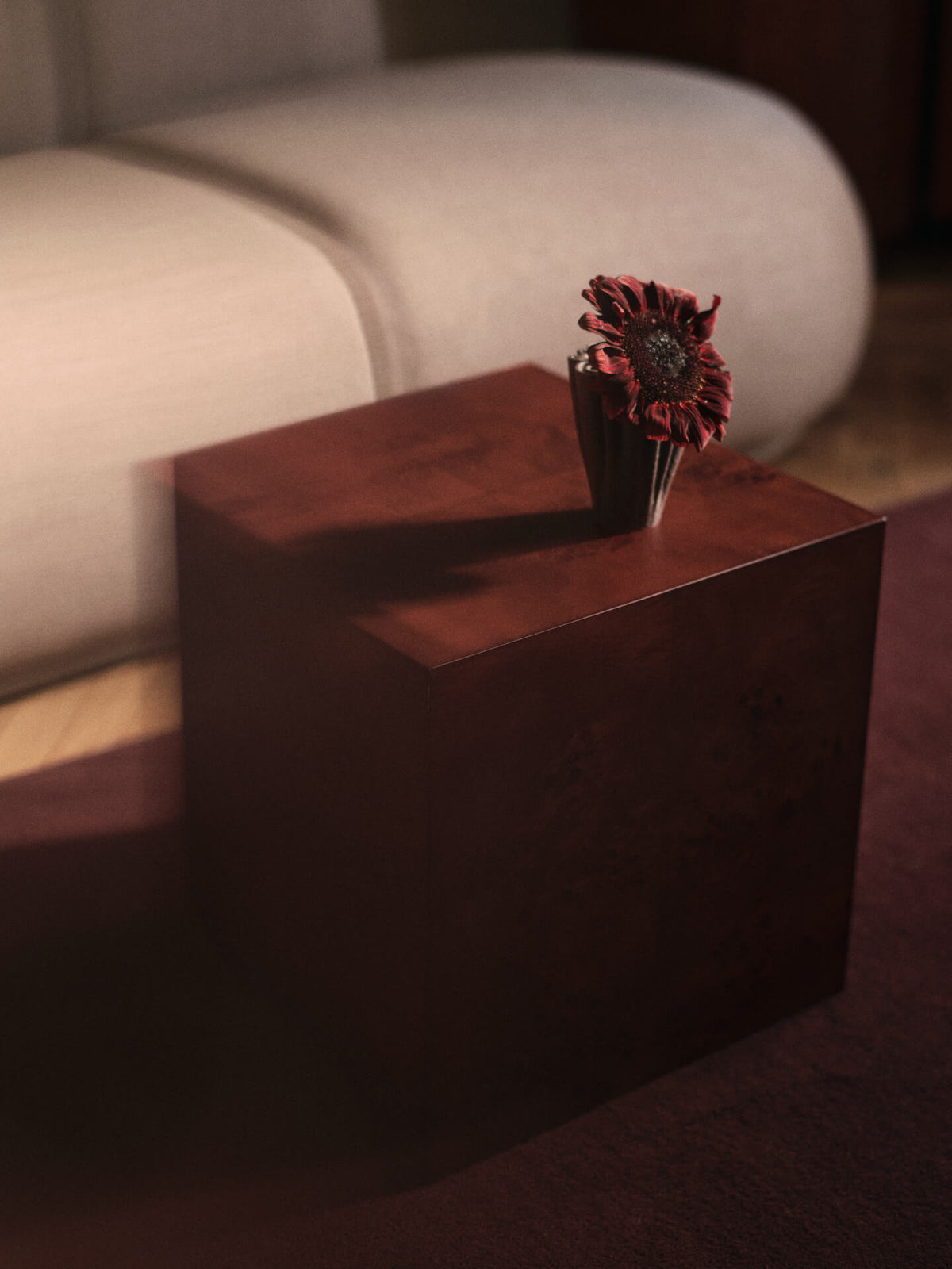 Petit vase Dedali brun foncé avec une fleur sur une table d’appoint