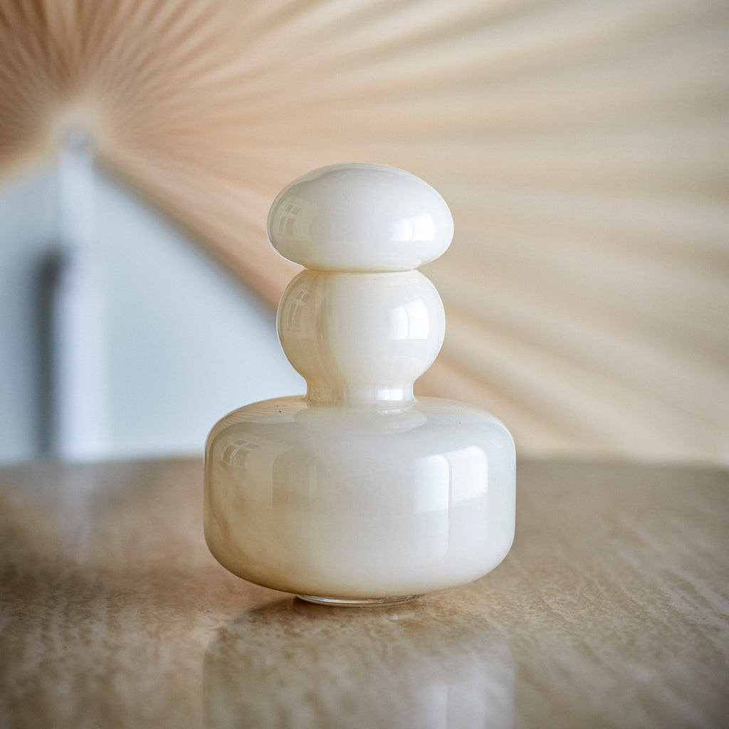 Vase Cynthia beige avec son couvercle posé sur une table