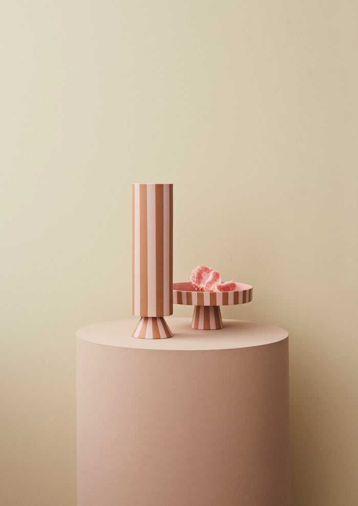 Vase Toppu haut caramel et rose posé sur un socle rose